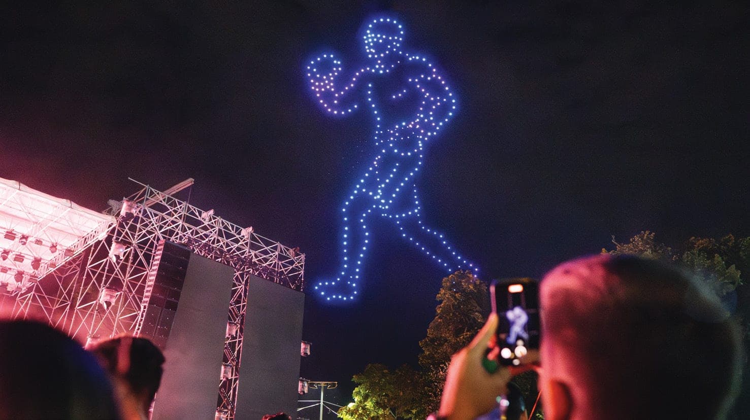 A FLYSTACK drone-formed figure performing over a live crowd