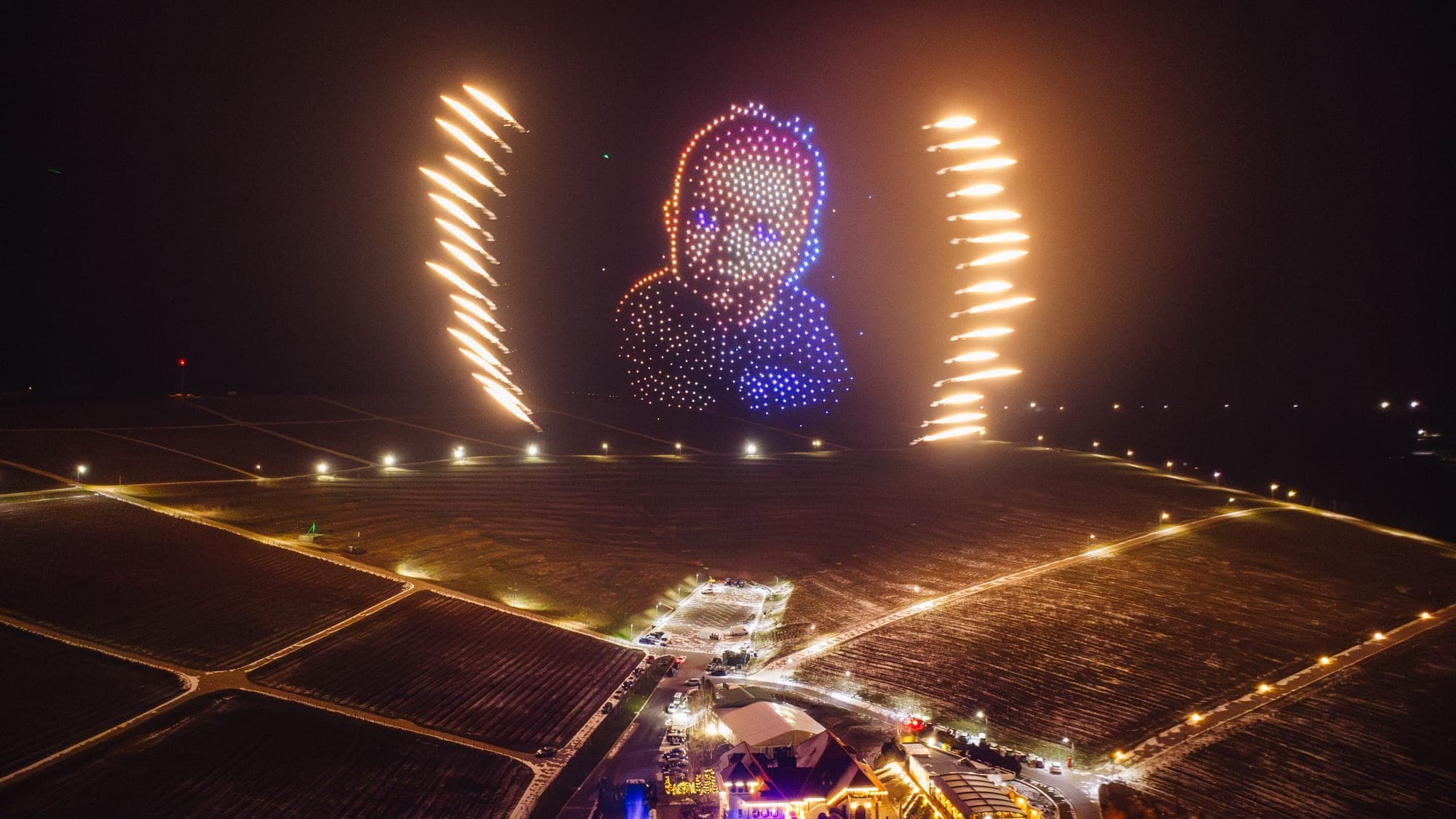 MD12 drone-show figure with pyrotechnic comets over a field