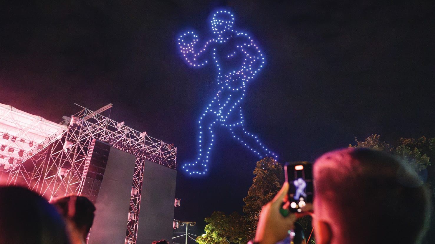 A FLYSTACK drone-formed figure performing over a live crowd